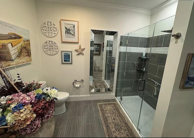 bathroom featuring toilet, a shower with door, and ornamental molding