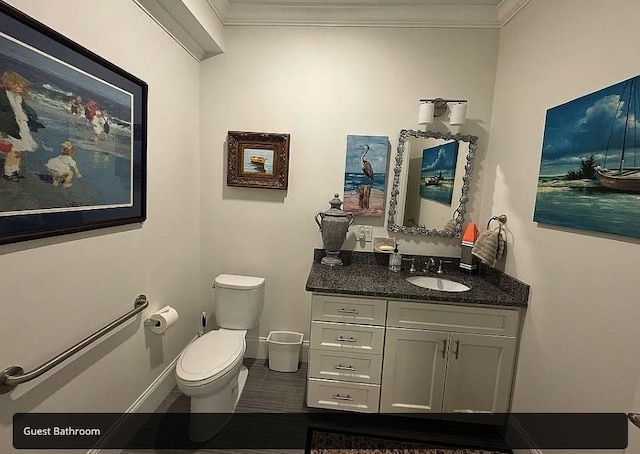 bathroom featuring crown molding, vanity, and toilet