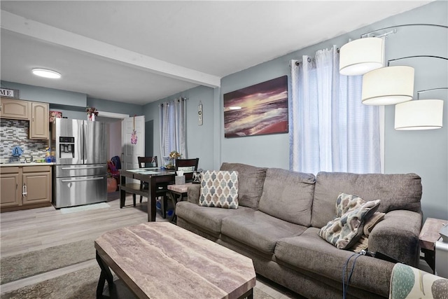 living room featuring beam ceiling and light hardwood / wood-style flooring