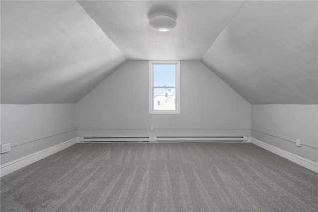 additional living space with vaulted ceiling, a baseboard radiator, and carpet flooring