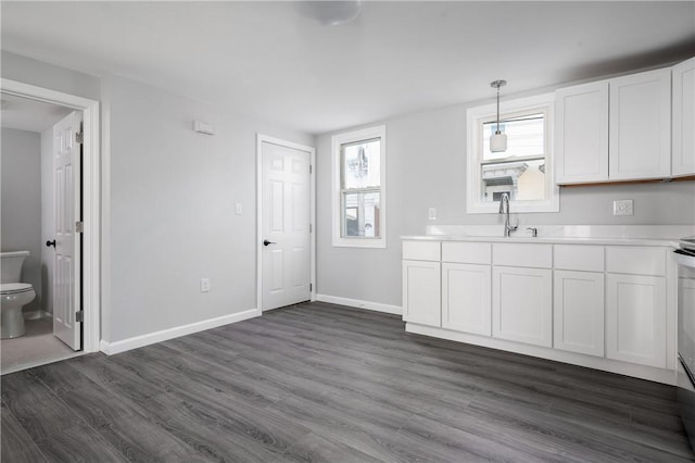 kitchen featuring sink, white cabinets, hanging light fixtures, and dark hardwood / wood-style floors