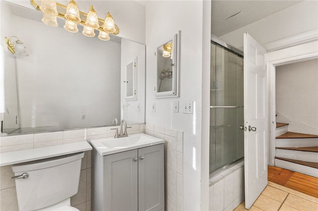 full bathroom with tile patterned flooring, vanity, toilet, and enclosed tub / shower combo