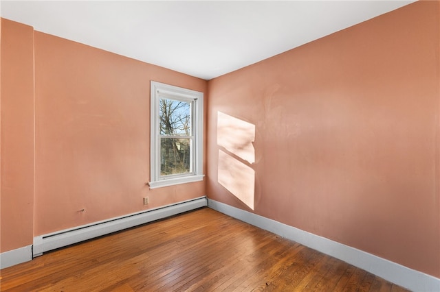 unfurnished room featuring a baseboard radiator and wood-type flooring