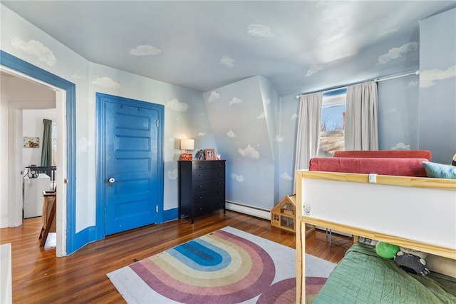 bedroom featuring dark hardwood / wood-style floors and a baseboard heating unit