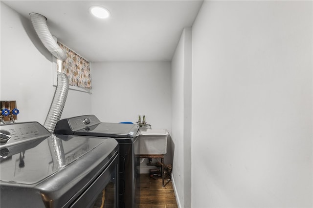 laundry room featuring washing machine and dryer, dark wood-type flooring, and sink