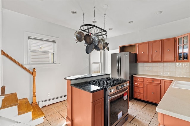 kitchen featuring backsplash, baseboard heating, stainless steel appliances, and light tile patterned floors