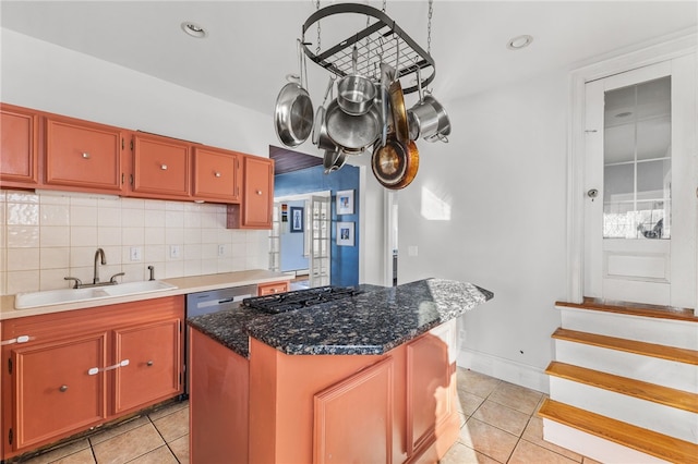 kitchen with backsplash, a center island, light tile patterned floors, and sink