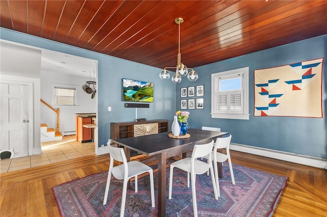 dining area featuring hardwood / wood-style floors, an inviting chandelier, and a baseboard heating unit