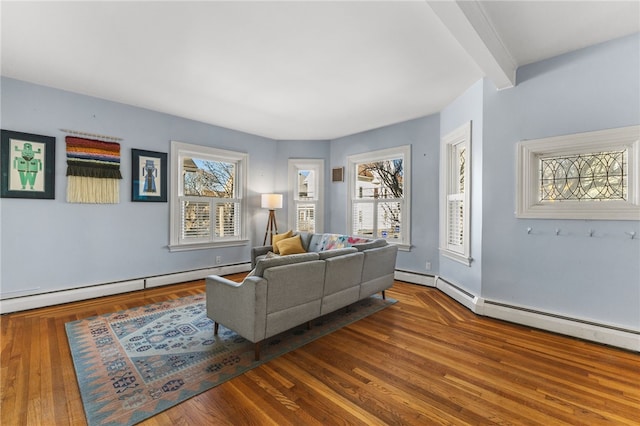 living room featuring beamed ceiling, wood-type flooring, and a baseboard heating unit