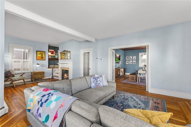 living room with a high end fireplace, hardwood / wood-style floors, baseboard heating, and beamed ceiling