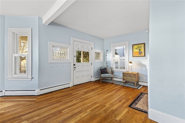 entrance foyer with beam ceiling, a baseboard radiator, and light hardwood / wood-style floors