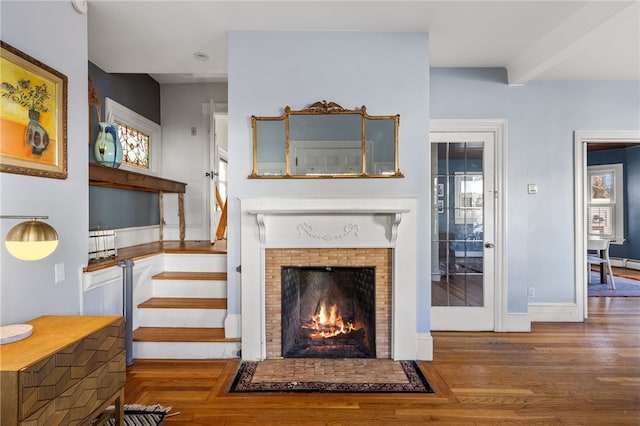 living room with wood-type flooring and a brick fireplace