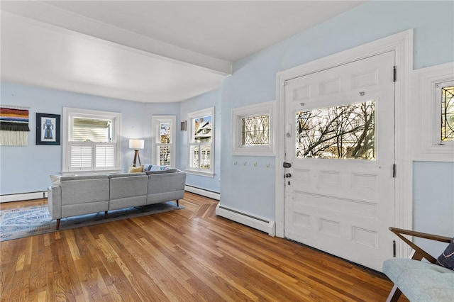 foyer featuring hardwood / wood-style flooring, beamed ceiling, and a baseboard heating unit