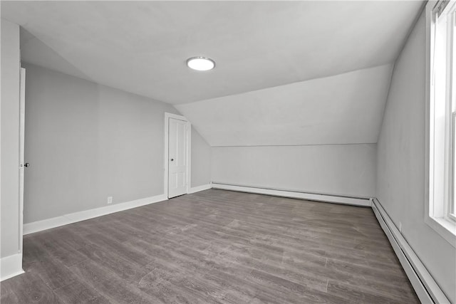 bonus room with vaulted ceiling, dark wood-type flooring, and a baseboard heating unit