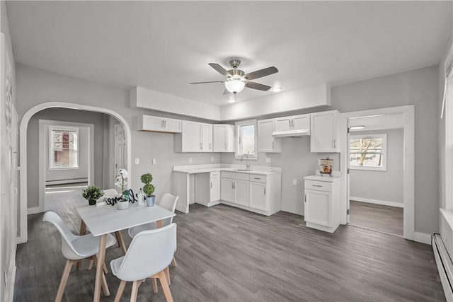 kitchen with ceiling fan, sink, white cabinets, and a baseboard radiator