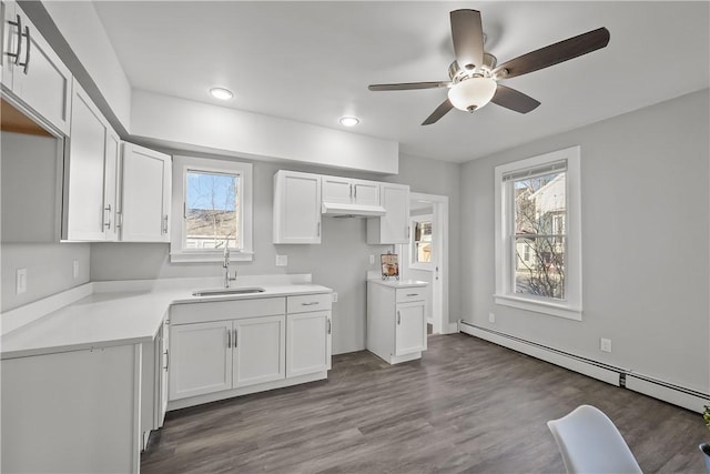 kitchen with white cabinetry, sink, and a baseboard radiator