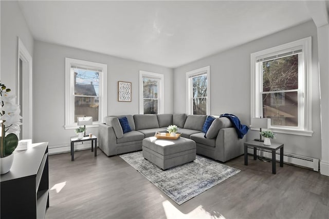 living room with a healthy amount of sunlight, dark hardwood / wood-style flooring, and a baseboard radiator