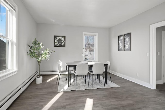 dining space with dark hardwood / wood-style flooring and a baseboard heating unit