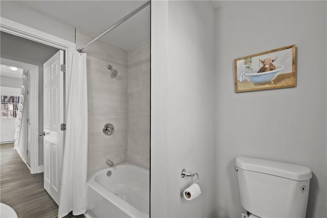 bathroom featuring shower / bathtub combination with curtain and toilet