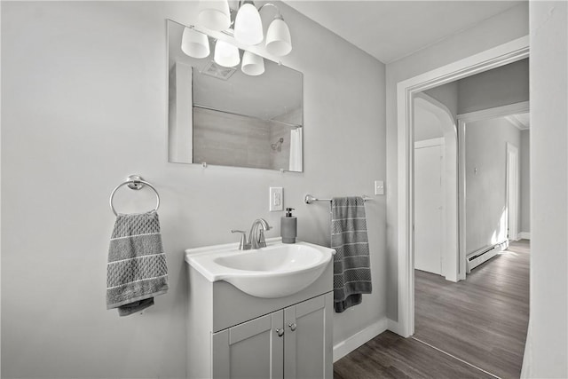 bathroom with vanity, hardwood / wood-style flooring, a baseboard radiator, curtained shower, and a chandelier