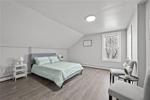 bedroom featuring hardwood / wood-style flooring, lofted ceiling, and a baseboard heating unit