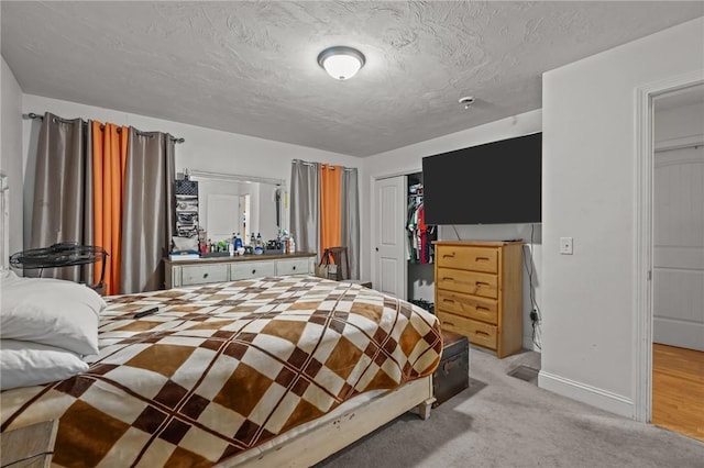 carpeted bedroom featuring a textured ceiling and a closet