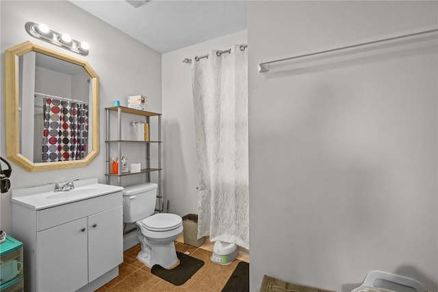 bathroom with tile patterned flooring, vanity, and toilet