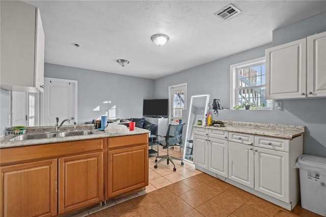 kitchen with sink, white cabinets, and light tile patterned floors