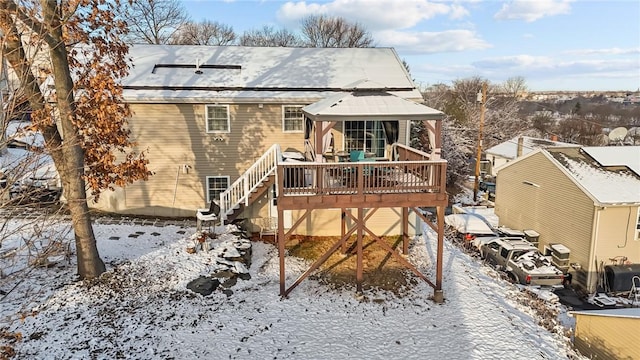 snow covered property featuring a wooden deck