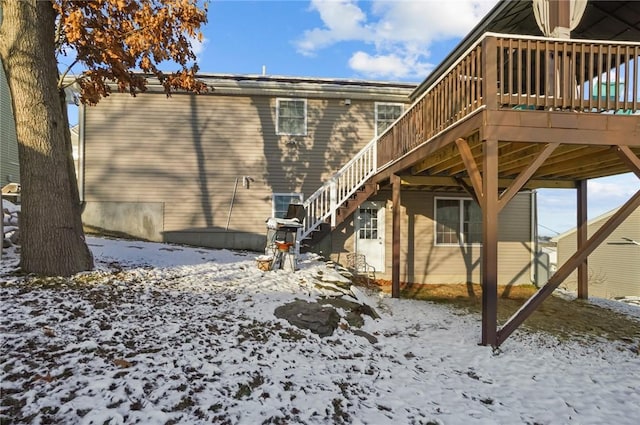 snow covered property with a wooden deck