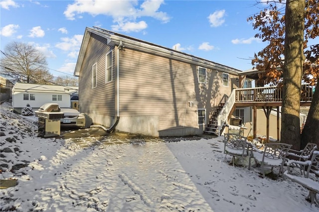 snow covered house with a deck