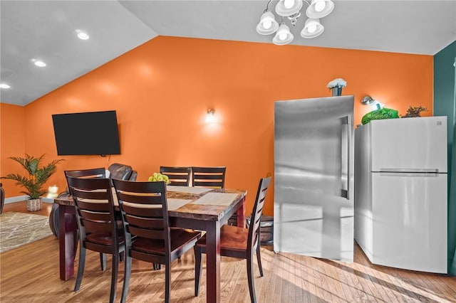 dining room with light hardwood / wood-style flooring and lofted ceiling