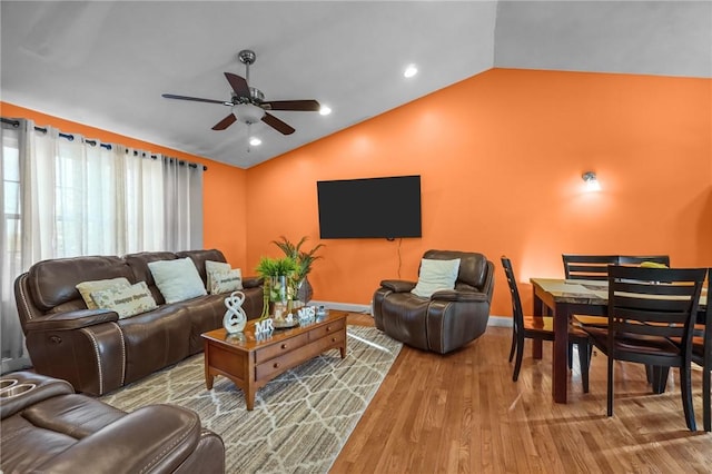 living room with ceiling fan, light hardwood / wood-style flooring, and lofted ceiling