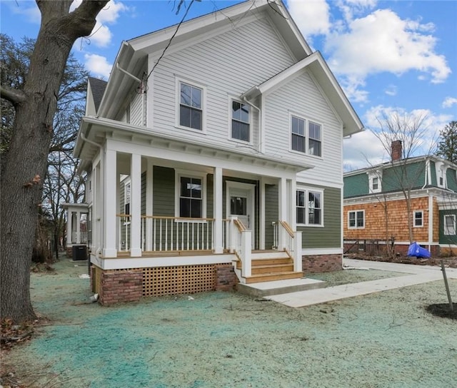 view of front facade with central air condition unit, a front lawn, and covered porch