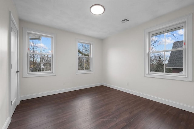 unfurnished room featuring dark hardwood / wood-style floors and a wealth of natural light