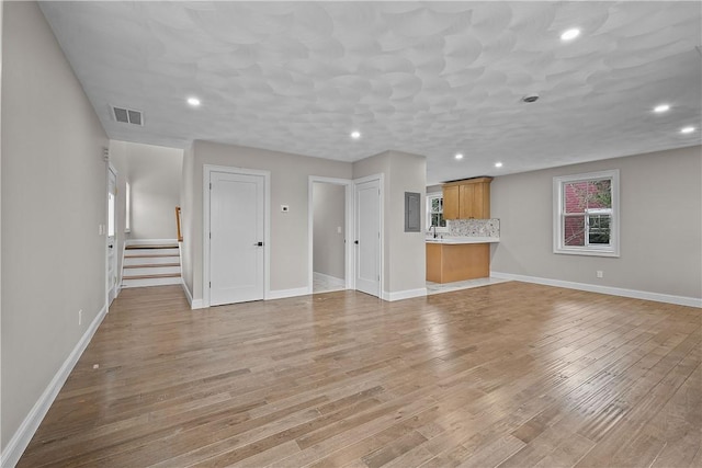 unfurnished living room with light wood-type flooring and sink