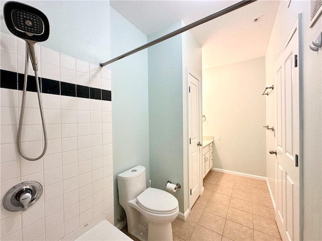 bathroom with tile patterned floors, vanity, toilet, and a tile shower