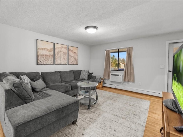 living room with hardwood / wood-style flooring, cooling unit, a textured ceiling, and a baseboard heating unit