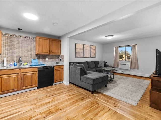 kitchen with sink, black dishwasher, light hardwood / wood-style flooring, a baseboard heating unit, and decorative backsplash