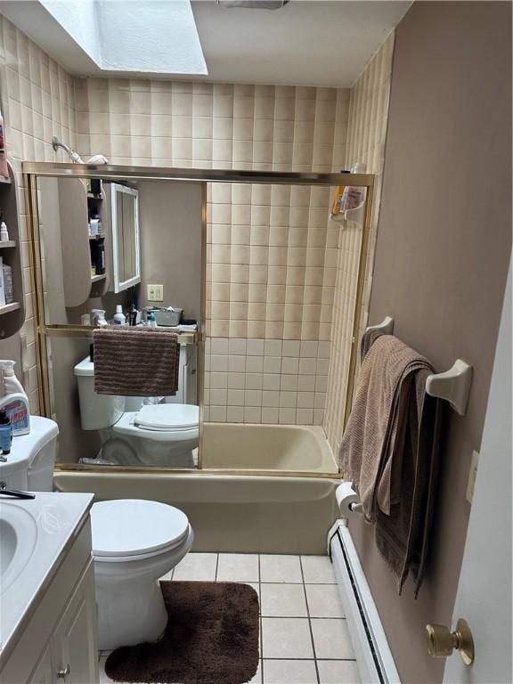 full bathroom with a skylight, tiled shower / bath combo, baseboard heating, tile patterned floors, and vanity