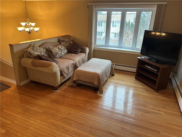 living room with a chandelier, light hardwood / wood-style floors, and a baseboard radiator