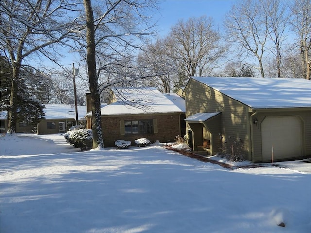 view of snow covered exterior with a garage