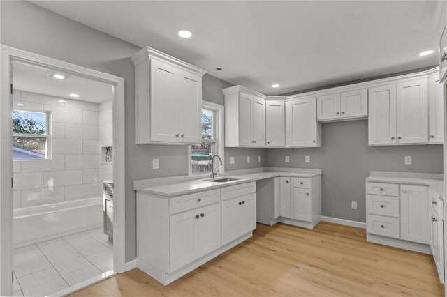 kitchen featuring white cabinets, sink, and light hardwood / wood-style flooring