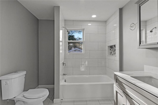 full bathroom featuring tile patterned flooring, vanity, toilet, and tiled shower / bath