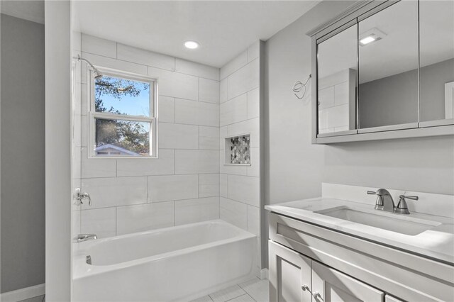 bathroom with tile patterned flooring, vanity, and tiled shower / bath combo