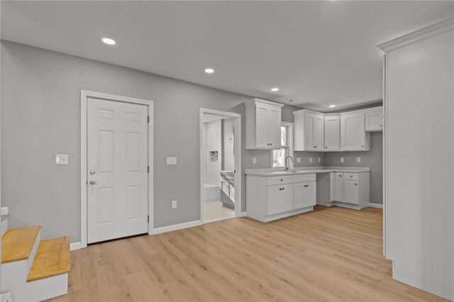 kitchen with sink, white cabinets, and light hardwood / wood-style floors