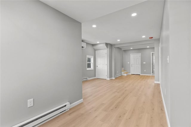 interior space with a wall mounted AC, light hardwood / wood-style flooring, and a baseboard heating unit