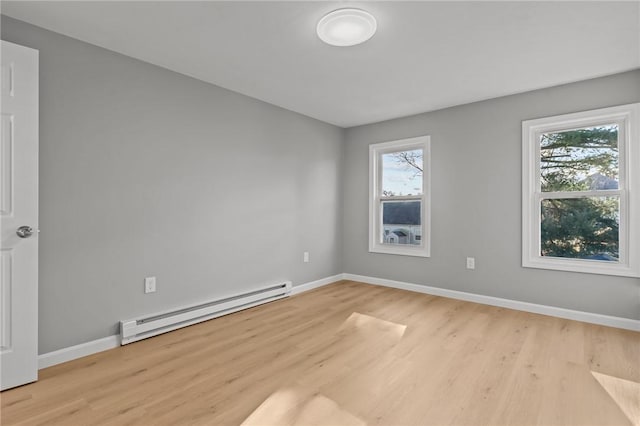 empty room with light hardwood / wood-style floors and baseboard heating