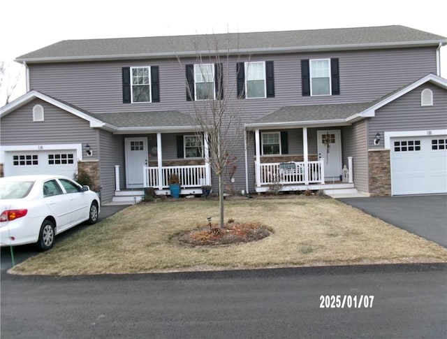 view of front facade with covered porch, a garage, and a front lawn