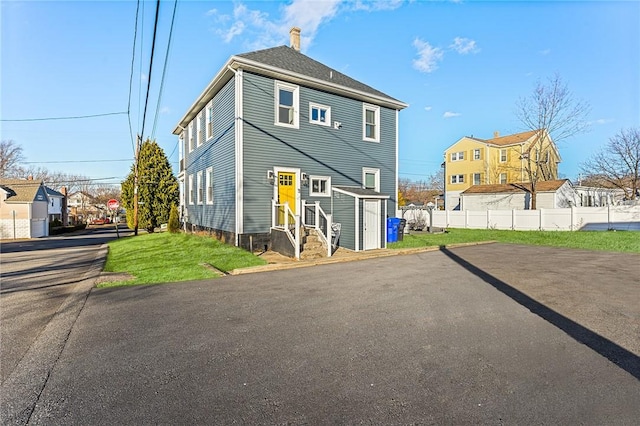 rear view of property featuring a lawn